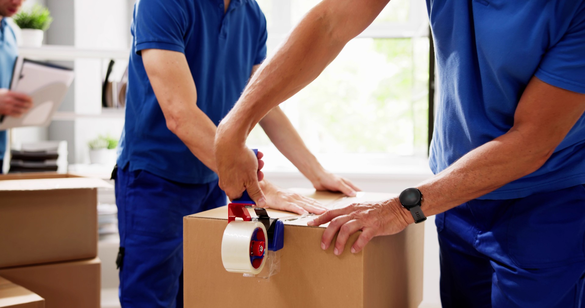 Professional movers carefully wrapping furniture in tape